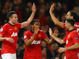 Robin van Persie of Manchester United celebrates scoring the second goal with his team-mates during the UEFA Champions League Round of 16 second round match against Olympiacos on March 19, 2014
