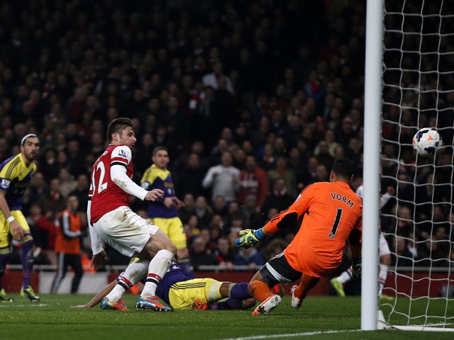 Arsenal's French striker Olivier Giroud shoots to score their second goal past Swansea City's Dutch goalkeeper Michel Vorm during the English Premier League football match between Arsenal and Swansea City at the Emirates Stadium in London on March 25, 201