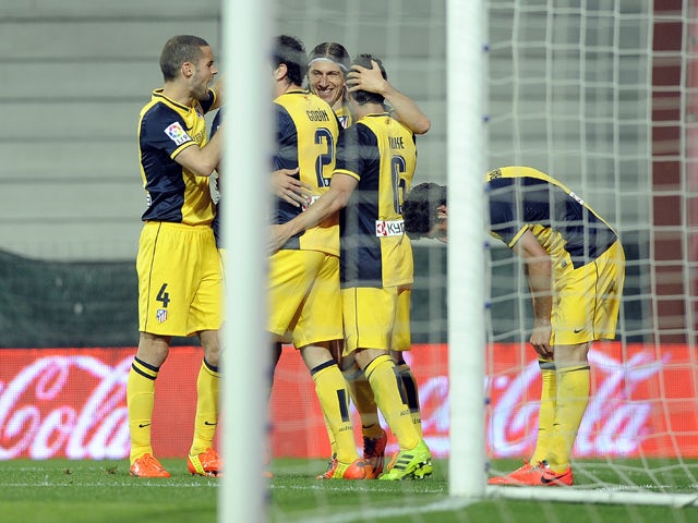 Atletico Madrid's players celebrate their second goal during the Spanish league football match Athletic Club Bilbao vs Atletico Madrid at the San Mames stadium in Bilbao on March 29, 2014