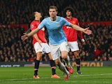 Edin Dzeko of Manchester City celebrates scoring the second goal during the Barclays Premier League match between Manchester United and Manchester City at Old Trafford on March 25, 2014