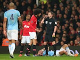 Marouane Fellaini of Manchester United is booked by Referee Michael Oliver for a challenge on Pablo Zabaleta of Manchester City during the Barclays Premier League match between Manchester United and Manchester City at Old Trafford on March 25, 2014