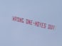 A plane flies overhead with a banner criticising Manchester United Manager David Moyes during the Barclays Premier League match between Manchester United and Aston Villa at Old Trafford on March 29, 2014
