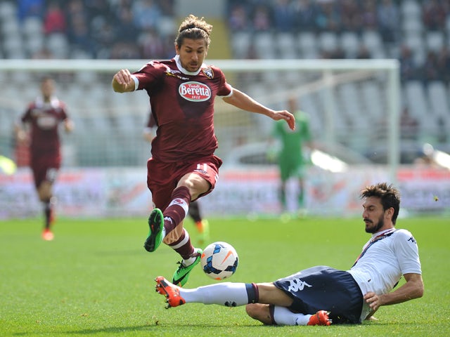 Alessio Cerci of Torino FC is challenged by Davide Astori of Cagliari Calcio during the Serie A match between Torino FC and Cagliari Calcio at Stadio Olimpico di Torino on March 30, 2014