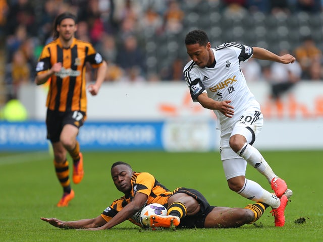 Hull City's Maynor Figueroa and Swansea City's Jonathan de Guzman compete or the ball during the Barclays Premier League match between Hull City and Swansea City at KC Stadium on April 5, 2014