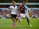 Lewis Holtby of Fulham is challenged by Joe Bennett of Aston Villa during the Barclays Premier League match between Aston Villa and Fulham at Villa Park on April 5, 2014