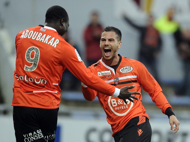 Lorient French forward Jeremie Aliadiere celebrates with his teammate Lorient's forward Vincent Aboubakar after scoring a goal during the French L1 football match between Lorient and Evian at Moustoir stadium in Lorient, western France, on April 05, 2014