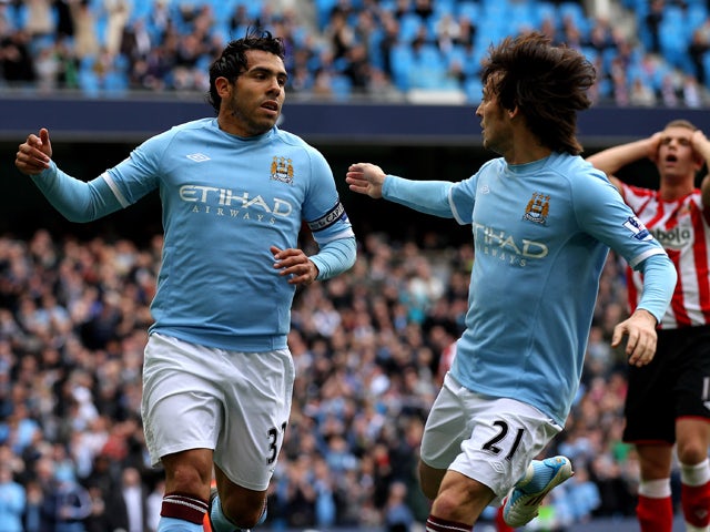 Carlos Tevez of Manchester City celebrates scoring his team's second goal, from a penalty, with team mate David Silva (R) during the Barclays Premier League match between Manchester City and Sunderland at the City of Manchester Stadium on April 3, 2011