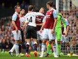 Jordan Henderson of Liverpool clashes with Matthew Taylor of West Ham during the Barclays Premier League match at Upton Park on April 6, 2014