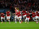 Arsenal's players celebrate after winning the FA Cup semi-final penalty shootout against Wigan Athletic at Wembley on April 12, 2014