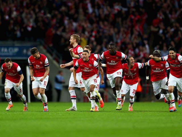 Arsenal's players celebrate after winning the FA Cup semi-final penalty shootout against Wigan Athletic at Wembley on April 12, 2014