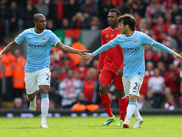 Manchester City's David Silva celebrates with team mate Fernandinho after scoring his team's first goal against Liverpool during the Premier League match on April 13, 2014