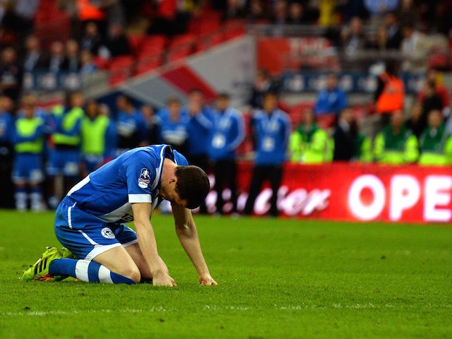 Wigan Athletic captain Gary Caldwell slumps to the ground after missing the first penalty of the FA Cup semi-final shootout against Arsenal at Wembley on April 12, 2014