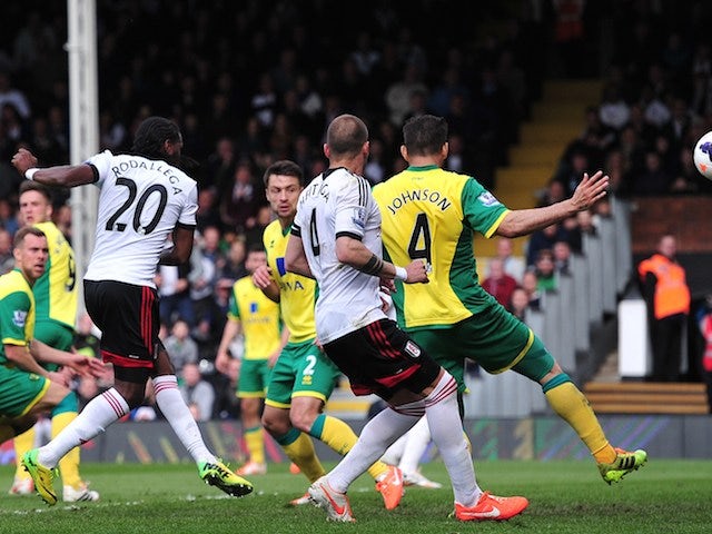Fulham's Colombian forward Hugo Rodallega (Foreground-L) shoots to score a goal during the English Premier League football match against Norwich City on April 12, 2014