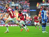 Per Mertesacker of Arsenal wheels away in delight after scoring the equaliser against Wigan Athletic in the FA Cup semi-final at Wembley on April 12, 2014