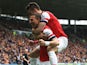 Lukas Podolski of Arsenal celebrates with team mate Olivier Giroud after scoring his sides third goal during the Barclays Premier League match between Hull City and Arsenal at KC Stadium on April 20, 2014