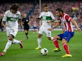 Adrian Lopez of Atletico de Madrid competes for the ball with Damian Suarez of Elche FC and his teammate Javier Marquez Moreno during the La Liga match between Club Atletico de Madrid and Elche FC at Vicente Calderon Stadium on April 18, 2014