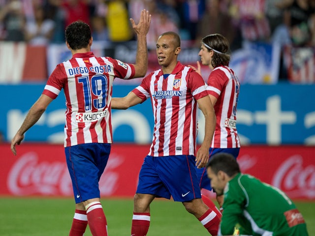 Joao Miranda of Atletico de Madrid claps his hands to celebrate scoring their opening goal with teammate Diego Costa and their teammate Filipe Luis as goalkeeper Manu Herrera of Elche FC reacts defeated during the La Liga match between Club Atletico de Ma
