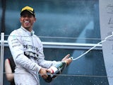 Lewis Hamilton of Mercedes celebrates with a bottle of champagne after winning the F1 Chinese Grand Prix on April 20, 2014
