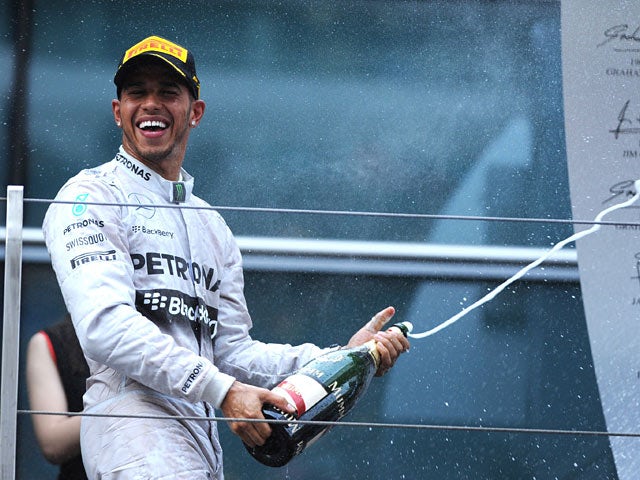 Lewis Hamilton of Mercedes celebrates with a bottle of champagne after winning the F1 Chinese Grand Prix on April 20, 2014