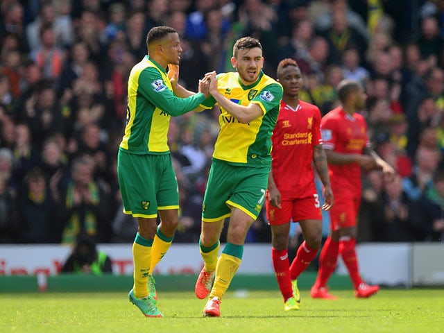 Norwich's Robert Snodgrass celebrates with teammate Martin Olsson after scoring his team's second goal against Liverpool during the Premier League match on April 20, 2014