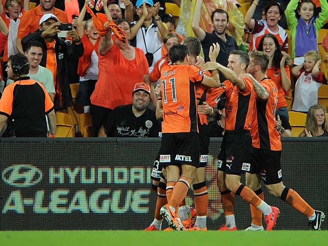 Brisbane Roar's Besart Berisha is congratulated by teammates in front of fans after scoring the opening goal against Melbourne Victory during the A-League semi-final match on April 27, 2014