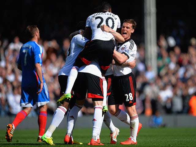 Fulham's Fernando Amorebieta is mobbed by teammates after scoring his team's second goal against Hull during the Premier League match on April 26, 2014