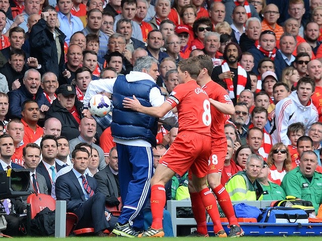 Liverpool midfielder Steven Gerrard tries to get the ball off Chelsea manager Jose Mourinho during the Premier League match at Anfield on April 27, 2014