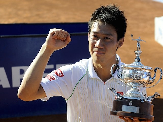 Japanese tennis player Kei Nishikori celebrates his victory with a replica trophy after beating Columbia's Santiago Giraldo during the ATP Final Barcelona on April 27, 2014