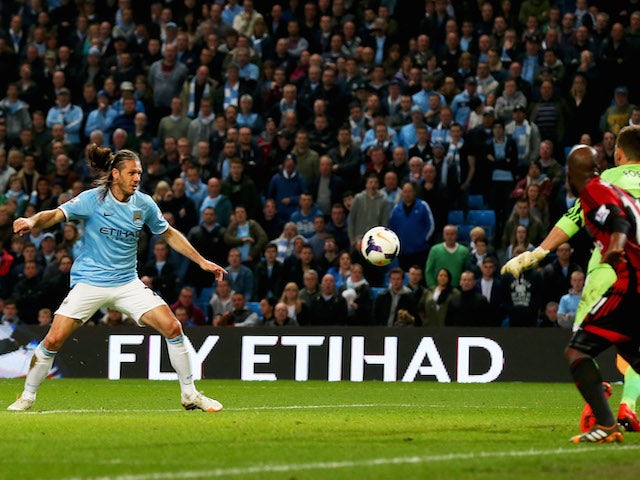 Martin Demichelis of Manchester City (L) scores their third goal past goalkeeper Ben Forster of West Bromwich Albion during the Barclays Premier League match on April 21, 2014