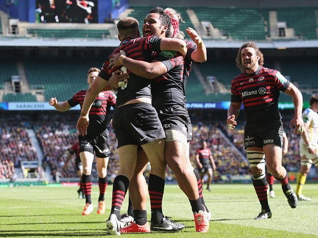 Saracens' Owen Farrell celebrates with teammates after scoring his team's third try against Clermont Auvergne during the Heineken Cup semi-final match on April 26, 2014