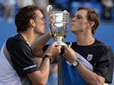 US brothers Bob Bryan and Mike Bryan kiss the trophy after winning the ATP Aegon Championships doubles final at Queen's Club, London on June 16, 2013