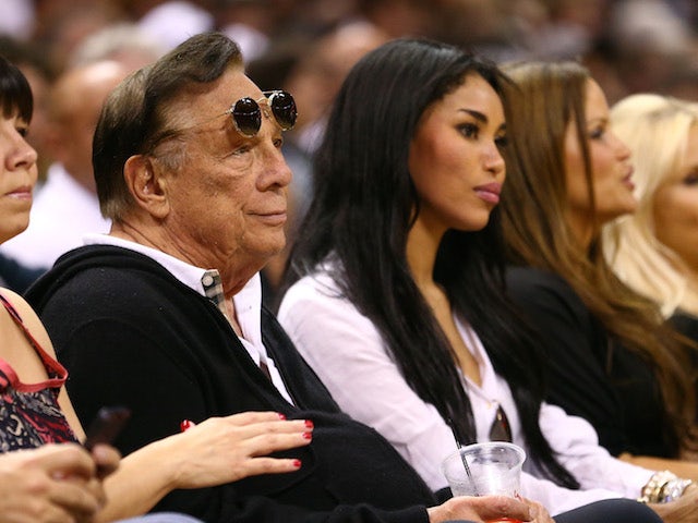 Team owner Donald Sterling of the Los Angeles Clippers and V. Stiviano look on at a basketball game on May 19, 2013