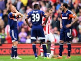 Steve Sidwell, Darren Bent and Konstantinos Mitroglou of Fulham react as their side concedes a third goal during the Barclays Premier League match between Stoke City and Fulham at the Britannia Stadium on May 3, 2014