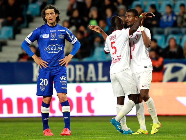 Lille's Ivorian forward Salomon Kalou is congratulated by teammate Senegalese midfielder Idrissa Gueye after scoring a goal as Bastia's French defender Francois Joseph Modesto reacts during the French L1 football match Sporting Club Bastia (SCB) against L