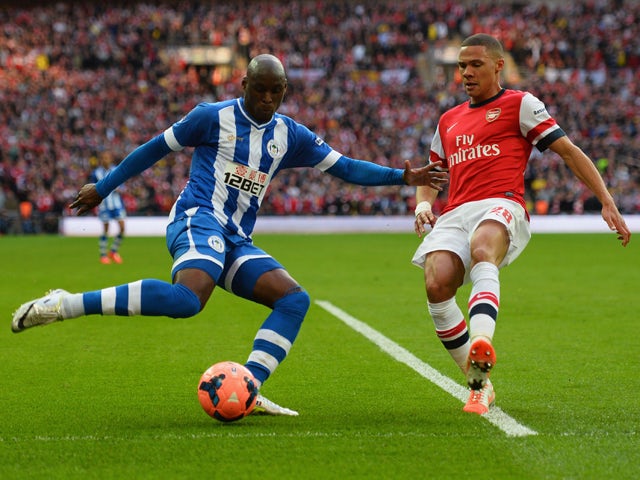 Marc-Antoine Fortune of Wigan Athletic crosses the ball under pressure from Kieran Gibbs of Arsenal during the FA Cup Semi-Final match between Wigan Athletic and Arsenal at Wembley Stadium on April 12, 2014