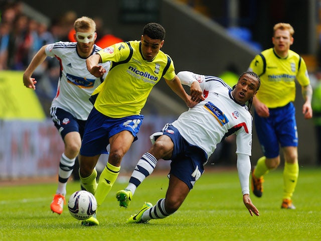 Neil Danns of Bolton Wanderers tackles Tom Adeyemi of Birmingham City during the Sky Bet Championship match on May 3, 2014