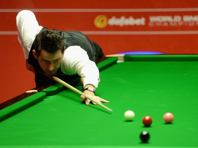 Ronnie O'Sullivan plays a shot against Joe Perry during their second round match in The Dafabet World Snooker Championship at Crucible Theatre on April 26, 2014