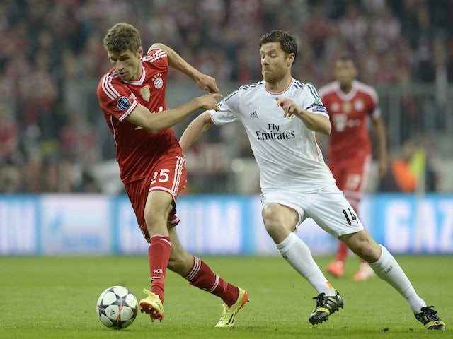 Bayern Munich's midfielder Thomas Mueller and Real Madrid's midfielder Xabi Alonso fight for the ball during the UEFA Champions League second-leg semi-final football match on April 29, 2014