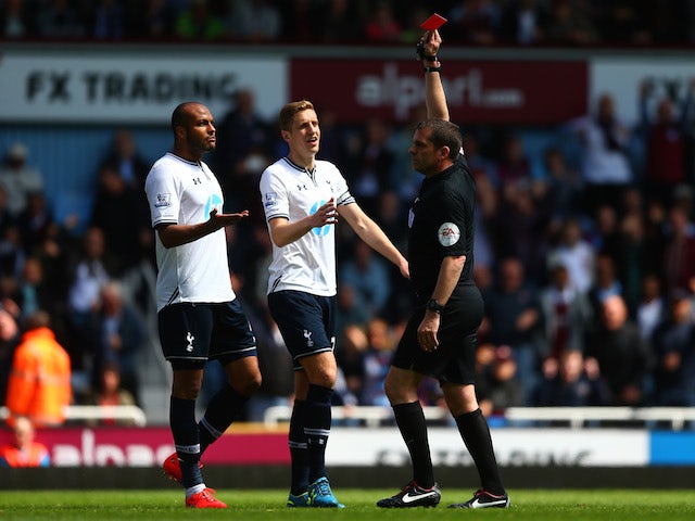 Referee Phil Dowd shows the red card to Younes Kaboul (L) of Spurs as Michael Dawson (C) of Spurs protests during the Barclays Premier League match against West Ham United on May 3, 2014