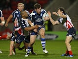 Ben Kavanagh of Scotland is tackled by Eddy Pettybourne of United States during the Rugby League World Cup Inter-Group match between Scotland and United States at AJ Bell Stadium on November 7, 2013