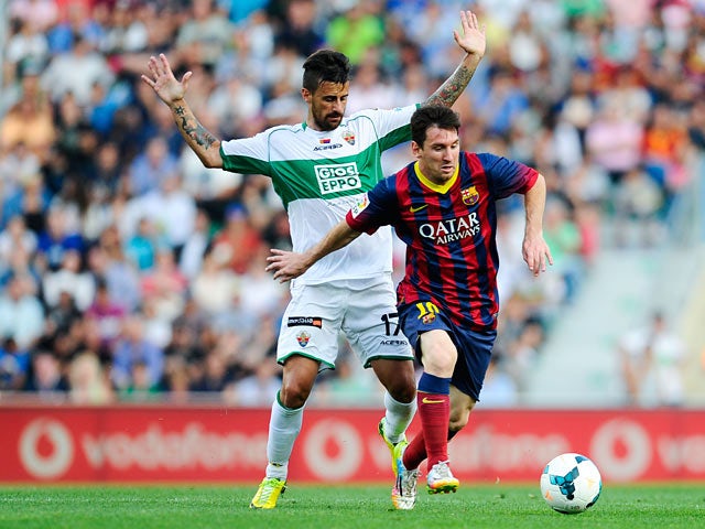 Barcelona's Lionel Messi and Elche's Javi Marquez in action during the La Liga match on May 11, 2014