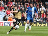 John Lundstram of Leyton Orient plays the ball watched by Michael Bostwick of Peterborough United during the Sky Bet League One Semi Final First Leg between Peterborough United and Leyton Orient at London Road Stadium on May 10, 2014