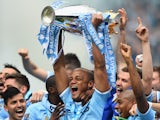 Vincent Kompany of Manchester City lifts the Premier League trophy at the end of the Barclays Premier League match between Manchester City and West Ham United at the Etihad Stadium on May 11, 2014