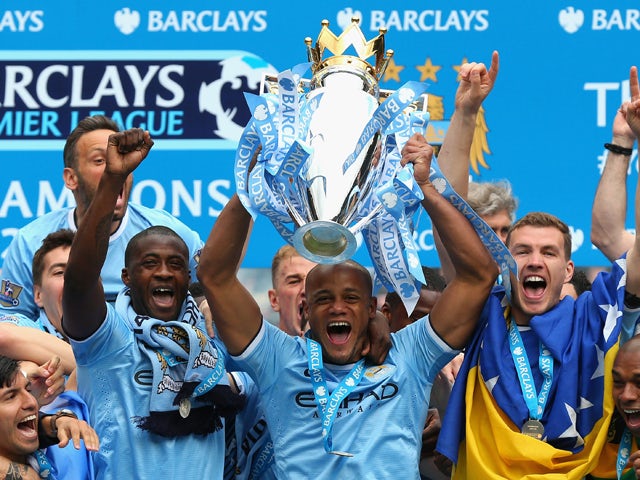 Vincent Kompany of Manchester City lifts the Premier League trophy at the end of the Barclays Premier League match between Manchester City and West Ham United at the Etihad Stadium on May 11, 2014