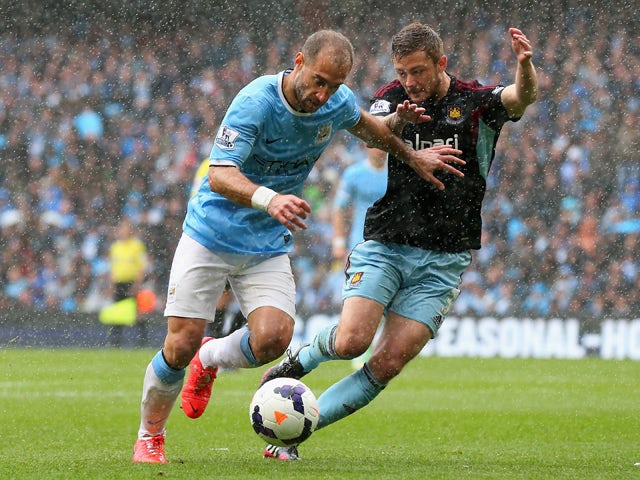 Pablo Zabaleta of Manchester City holds off George McCartney of West Ham United during the Barclays Premier League match between Manchester City and West Ham United at the Etihad Stadium on May 11, 2014