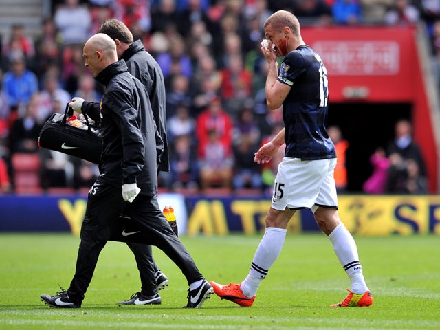 Manchester United's Serbian defender Nemanja Vidic walks off to get treated for a bloody nose during during the English Premier League football match between Southampton and Manchester United at St Mary's stadium in in Southampton on May 11, 2014