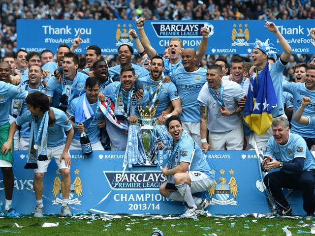  The Manchester City players celebrate with the Premier League trophy at the end of the Barclays Premier League match between Manchester City and West Ham United at the Etihad Stadium on May 11, 2014