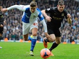 Manchester City midfielder James Milner (R) vies with Blackburn Rovers midfielder Tom Cairney (L) during the FA Cup third round match on January 4, 2014