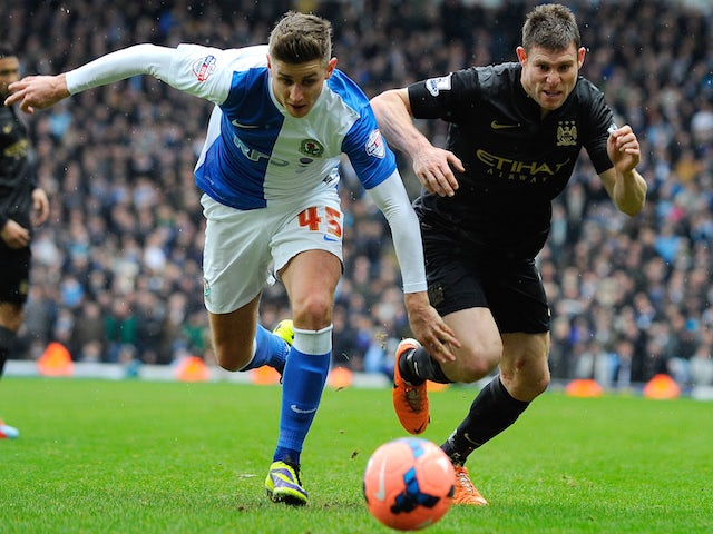 Manchester City midfielder James Milner (R) vies with Blackburn Rovers midfielder Tom Cairney (L) during the FA Cup third round match on January 4, 2014
