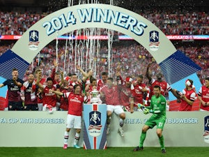 Arsenal players celebrate victory with the trophy after the FA Cup with Budweiser Final match between Arsenal and Hull City at Wembley Stadium on May 17, 2014